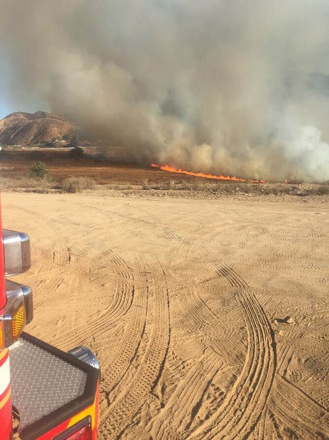 Burning vehicle starts fire.